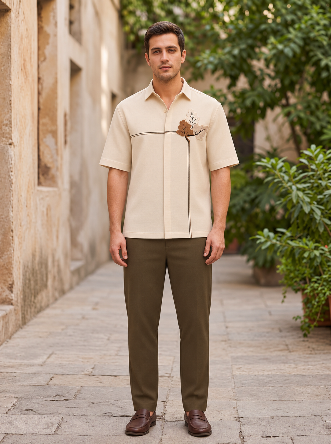 Snipes men’s boxy fit embroidered shirt displayed on a polished outfit along a garden walkway