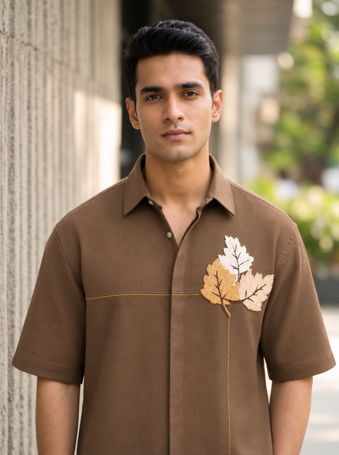 Man wearing a brown Snipes men’s boxy fit embroidered shirt